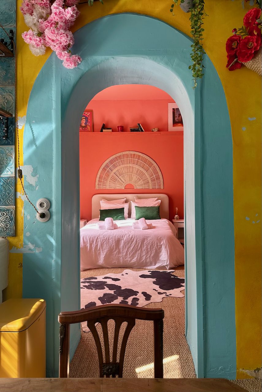 Arche turquoise ouvrant sur une chambre rose et corail